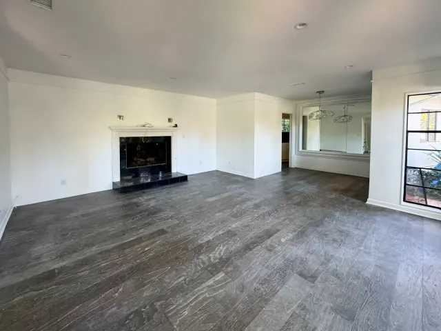 Gray wood-look plank flooring across an open living room with a fireplace in a Los Angeles full remodel