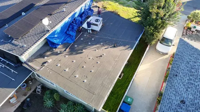 Van Nuys job with mold remediation, roofing and HVAC work: crew at the rooftop HVAC unit