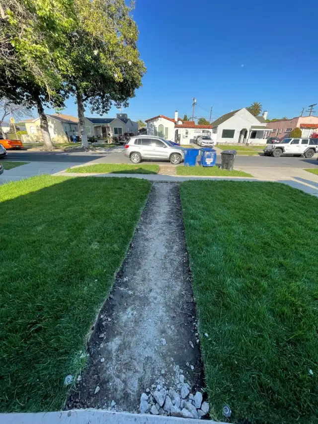 Outdoor and landscape in Los Angeles: a front walkway dug out and leveled between two lawns before the base goes in
