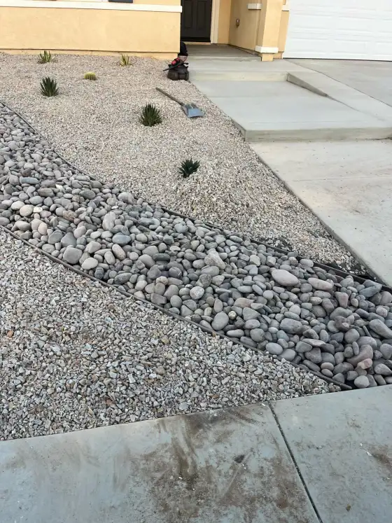 Front yard in Menifee finished with gravel, a band of river rock and young succulents