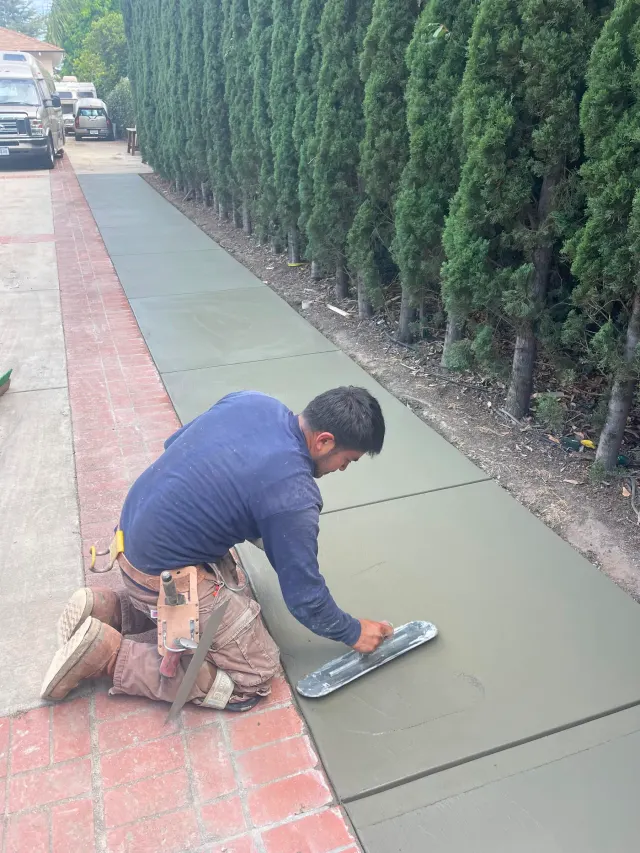 Outdoor and landscape in Walnut: a crew member finishing a freshly poured concrete walkway