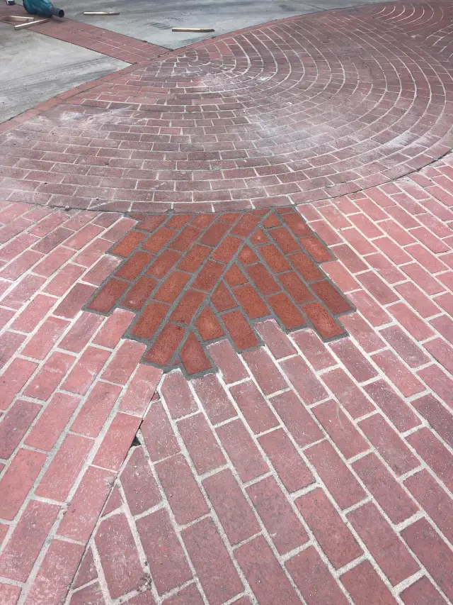 Outdoor and landscape in Walnut: brick pavers laid in a circle pattern, with a section relaid in new pavers