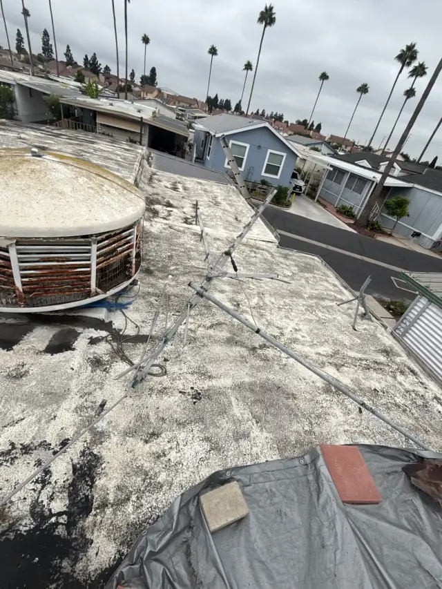 Roofing in Santa Ana: an old, rusted rooftop cooling unit on the flat roof