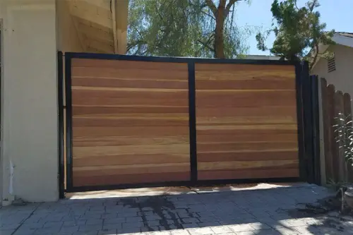 Wood driveway gate in a black steel frame