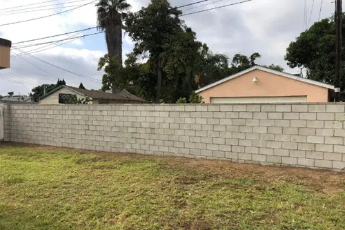 New concrete block wall along a backyard lawn
