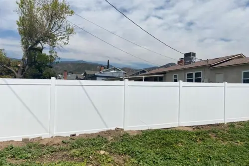 White vinyl privacy fence along a backyard